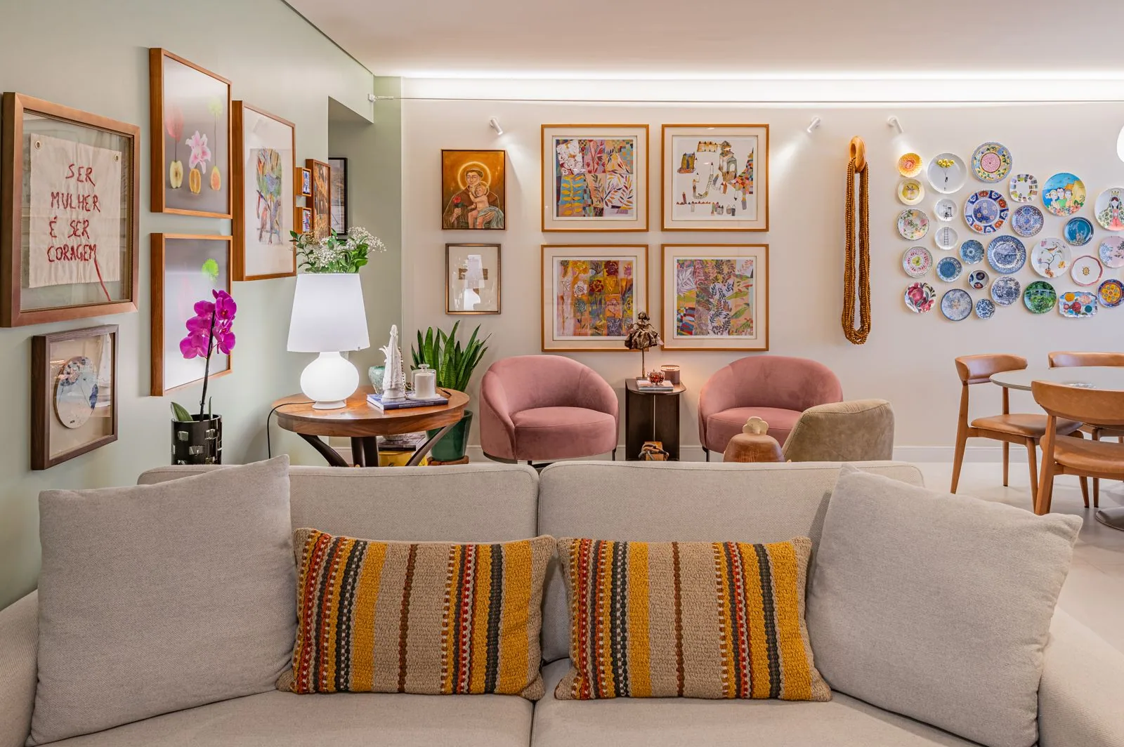 Sala de estar projetada por Felipe Fraga, com sofá em terracota e iluminação quente